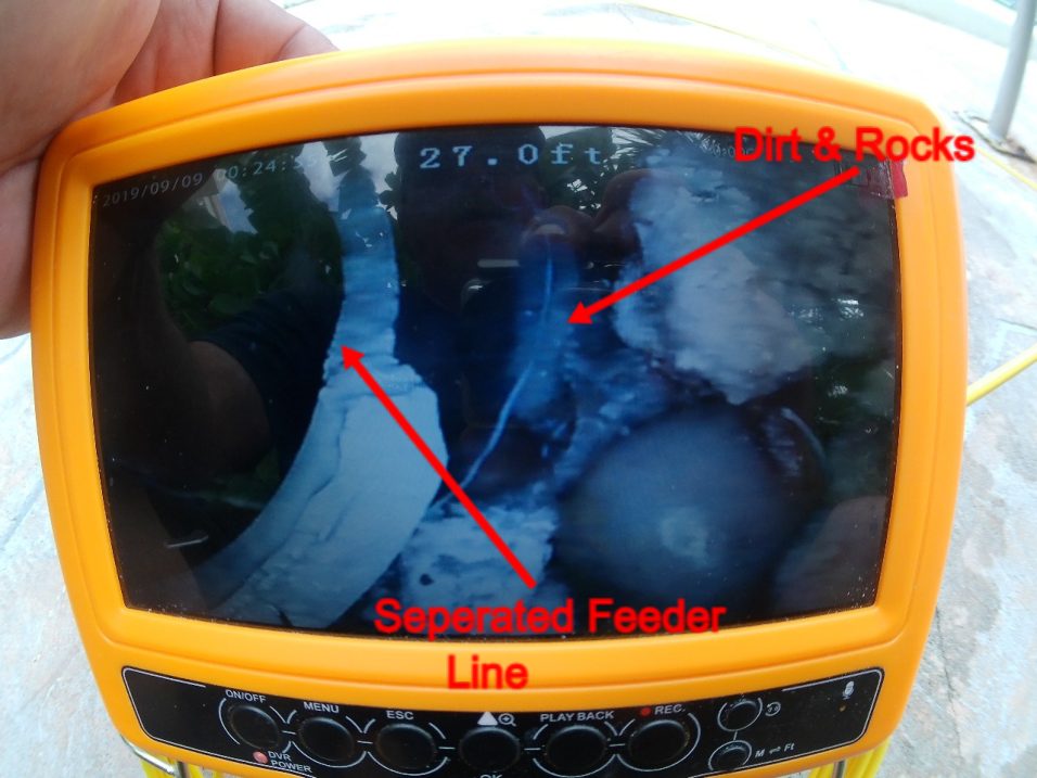 Pipe camera view marked to show the separated feeder line and dirt and rocks
