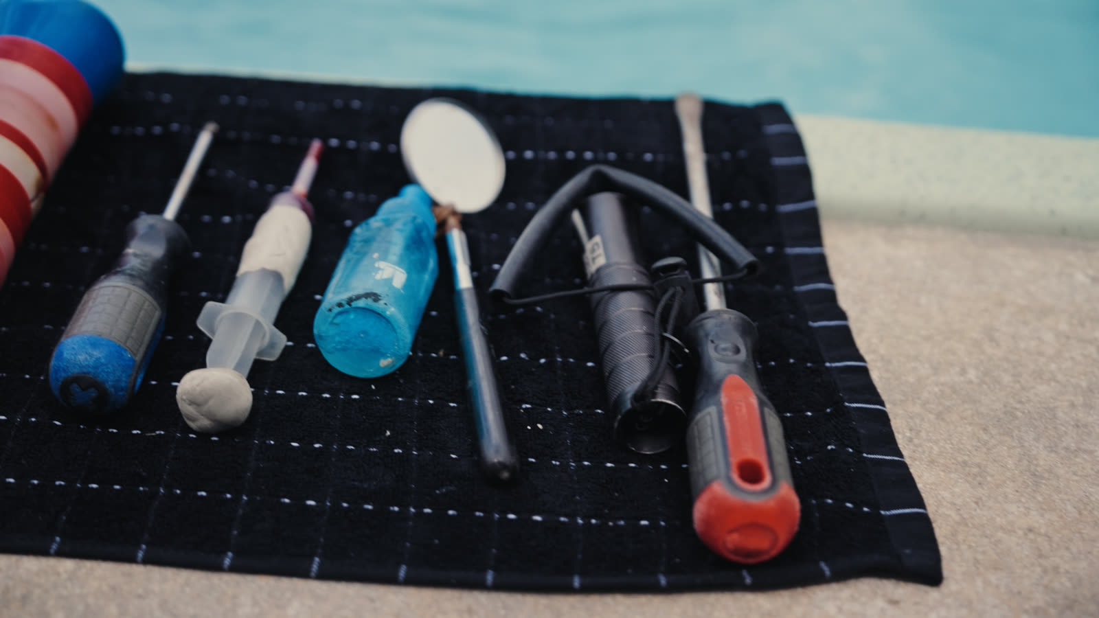Dye testing kit laid out poolside for pool leak detection training