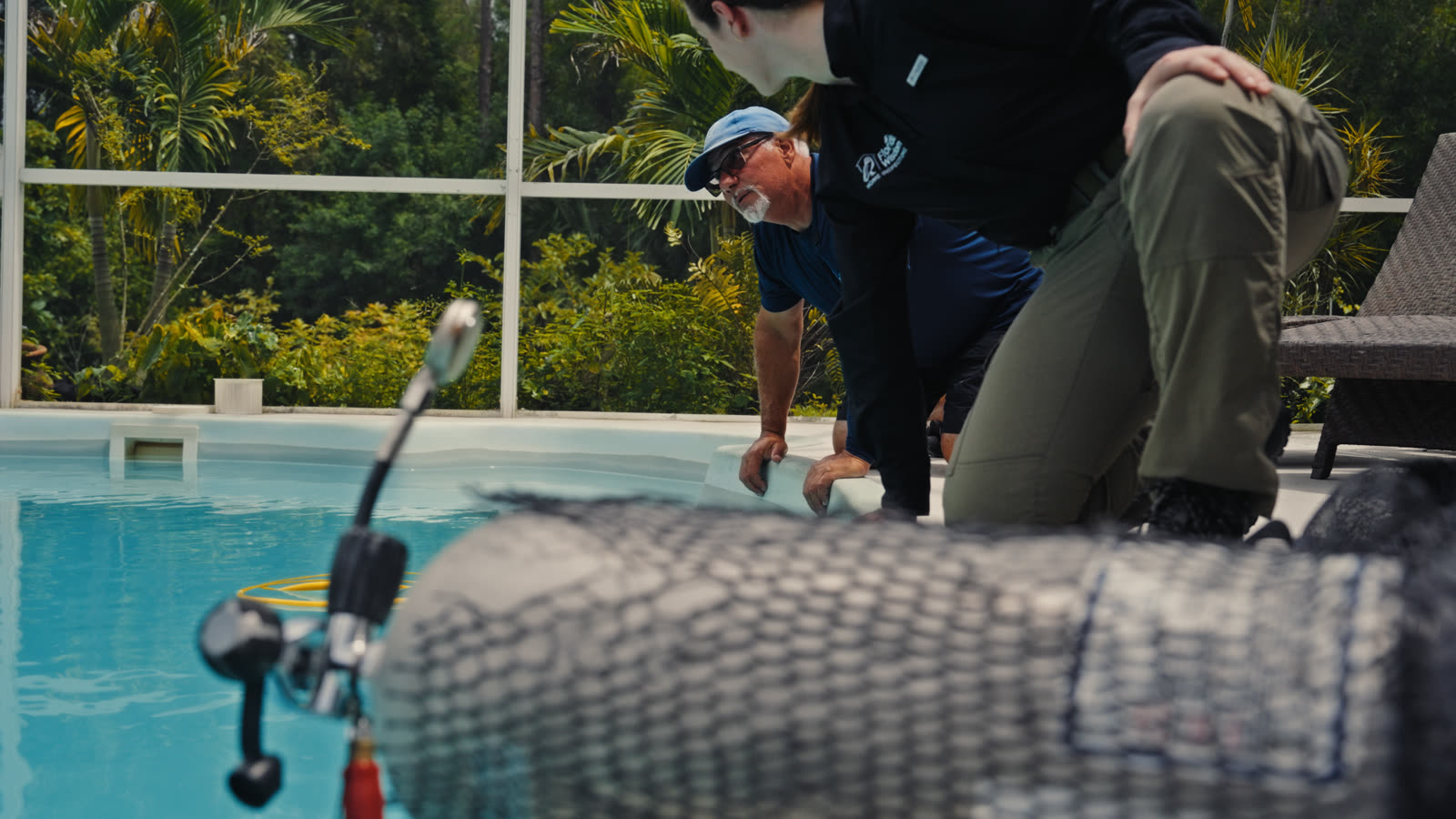 Students kneeling poolside with a hydrophone testing an equalizer line